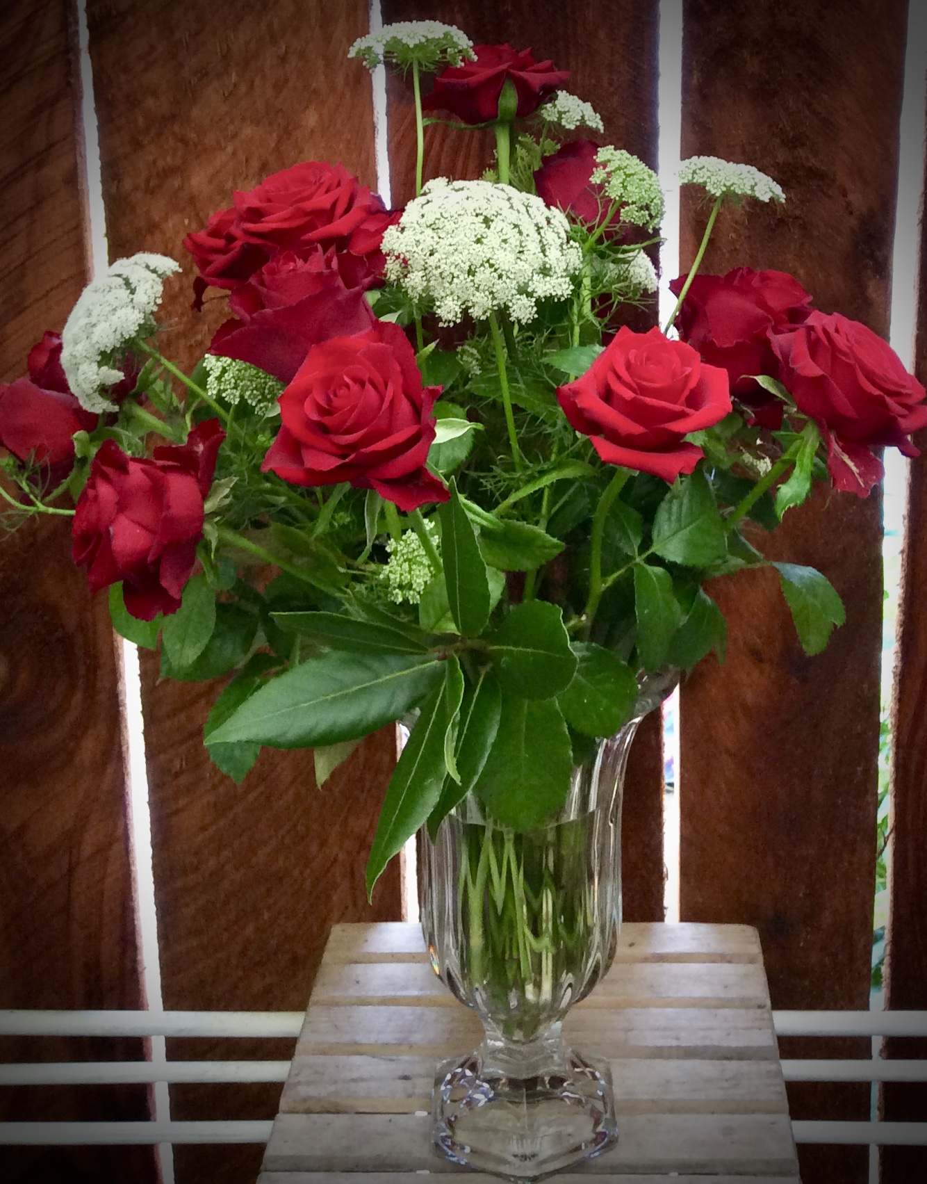 red roses for valentines arranged in a crystal vase.